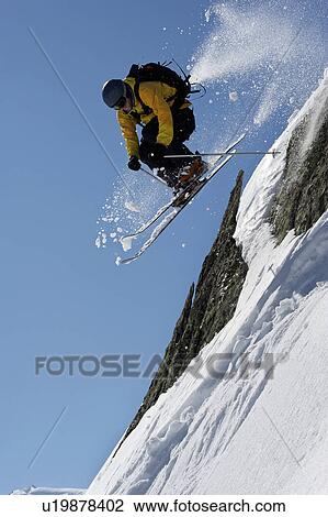 Skier jumping over steep mountain face View Large Photo Image Stock Image - Skier jumping over steep mountain face. Fotosearch