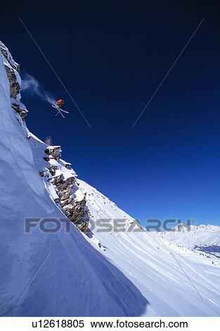 Skier making jump on mountainside View Large Photo Image Stock Photography - Skier making jump on mountainside. Fotosearch
