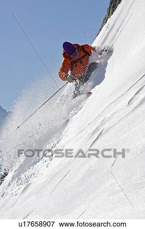 Stock Photo - Skier turning on steep mountain face. Fotosearch