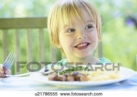 Smiling boy eating plate of food View Large Photo Image Stock Photography - Smiling boy eating plate of food. Fotosearch