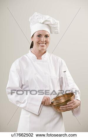 Stock Image - Smiling chef holding mixing bowl. Fotosearch