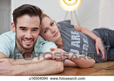 Smiling couple embracing on floor View Large Photo Image Picture - Smiling couple embracing on floor. Fotosearch
