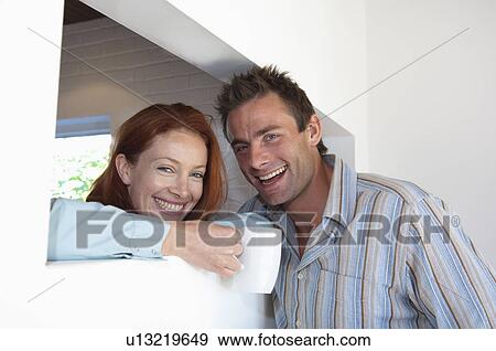 Smiling couple having coffee together View Large Photo Image Stock Photo - Smiling couple having coffee together . Fotosearch