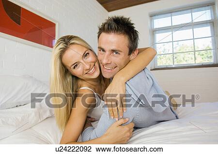 Smiling couple hugging in bed View Large Photo Image Stock Image - Smiling couple hugging in bed. Fotosearch