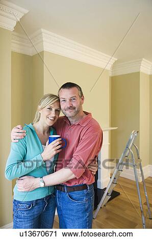Smiling couple hugging in new home View Large Photo Image Stock Image - Smiling couple hugging in new home. Fotosearch
