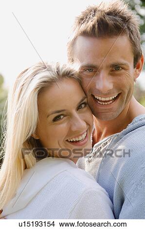 Smiling couple hugging outdoors View Large Photo Image Picture - Smiling couple hugging outdoors. Fotosearch