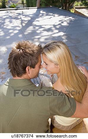 Picture - Smiling couple hugging outdoors. Fotosearch