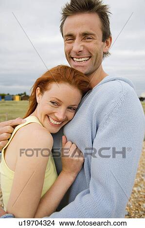 Smiling couple hugging outdoors View Large Photo Image Picture - Smiling couple hugging outdoors. Fotosearch