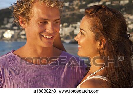 Stock Photo - Smiling couple hugging outdoors. Fotosearch