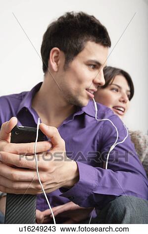 Smiling couple listening to headphones View Large Photo Image Stock Image - Smiling couple listening to headphones. Fotosearch