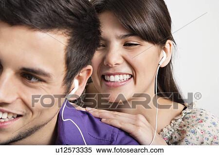 Smiling couple listening to headphones View Large Photo Image Stock Photography - Smiling couple listening to headphones. Fotosearch