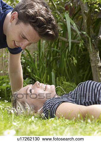 Smiling couple playing in grass View Large Photo Image Stock Image - Smiling couple playing in grass. Fotosearch