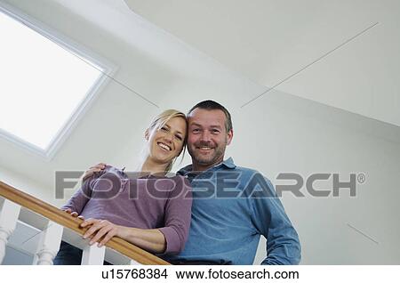 Picture - Smiling couple standing on stairs. Fotosearch