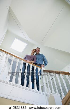 Smiling couple standing on stairs View Large Photo Image Stock Photograph - Smiling couple standing on stairs. Fotosearch
