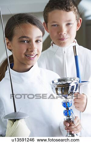 Stock Photograph - Smiling girl holding fencing trophy. Fotosearch