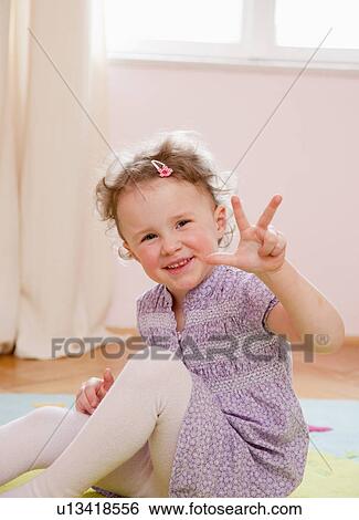 Smiling girl holding up three fingers View Large Photo Image Stock Photograph - Smiling girl holding up three fingers. Fotosearch