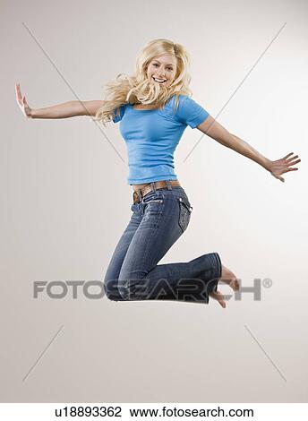 Smiling girl jumping in mid air View Large Photo Image Stock Image - Smiling girl jumping in mid air. Fotosearch
