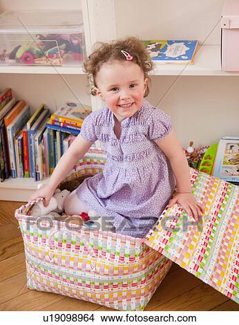 Smiling girl playing in toy basket View Large Photo Image Picture - Smiling girl playing in toy basket. Fotosearch