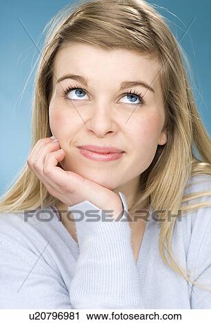 Stock Image - Smiling girl resting chin in hand. Fotosearch