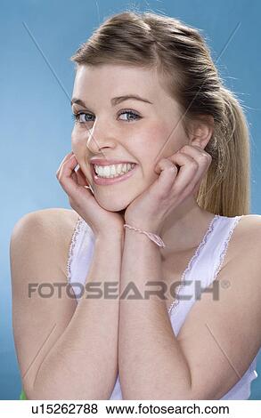 Stock Photo - Smiling girl resting chin in hands. Fotosearch
