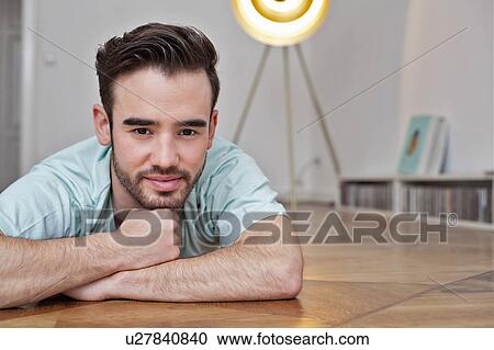 Smiling man laying on floor View Large Photo Image Stock Image - Smiling man laying on floor. Fotosearch
