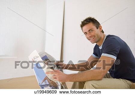 Smiling man reading newspaper View Large Photo Image Stock Photo - Smiling man reading newspaper. Fotosearch