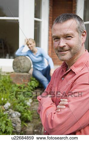 Stock Photo - Smiling man standing in backyard. Fotosearch