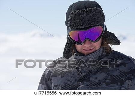 Stock Photograph - Smiling man wearing ski goggles. Fotosearch