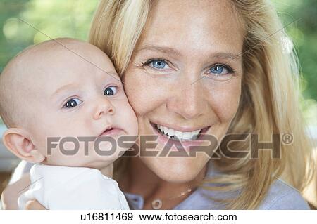 Stock Photo - Smiling mother holding baby. Fotosearch