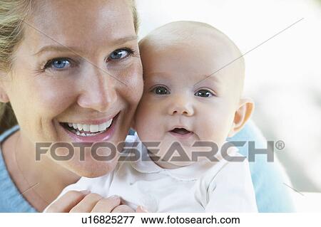 Stock Photo - Smiling mother holding baby. Fotosearch