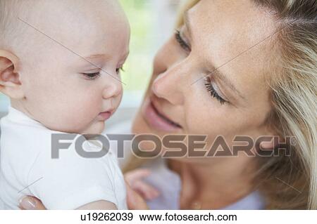 Smiling mother holding baby View Large Photo Image Stock Photo - Smiling mother holding baby. Fotosearch