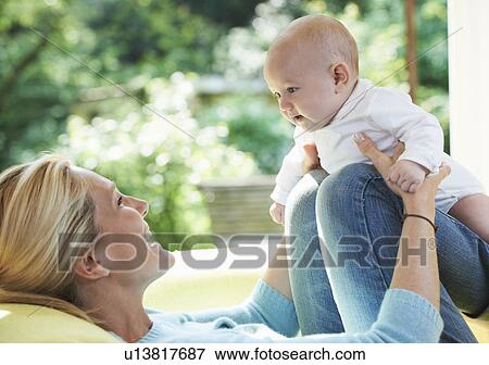 Stock Photo - Smiling mother playing with baby. Fotosearch