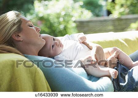 Smiling mother relaxing with baby View Large Photo Image Stock Photo - Smiling mother relaxing with baby. Fotosearch