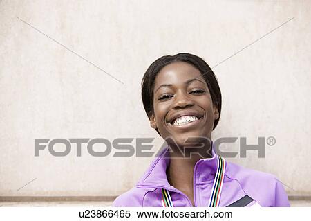 Stock Photography - Smiling runner wearing medal. Fotosearch
