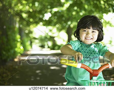 Smiling toddler girl riding bike View Large Photo Image Picture - Smiling toddler girl riding bike. Fotosearch