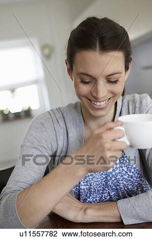 Smiling woman drinking cup of coffee View Large Photo Image Stock Image - Smiling woman drinking cup of coffee. Fotosearch