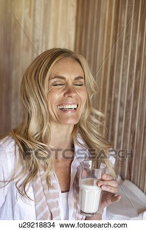Picture - Smiling woman drinking glass of milk. Fotosearch