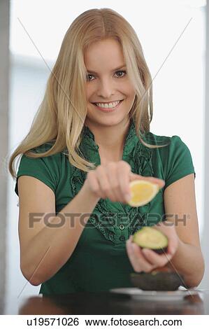 Stock Photograph - Smiling woman eating at table. Fotosearch