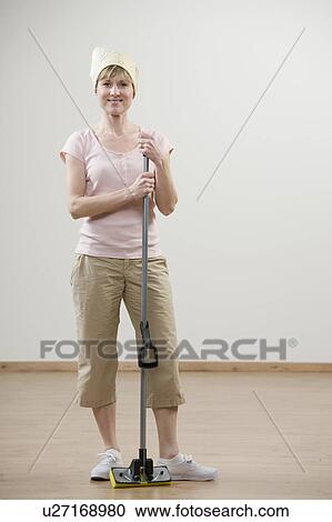 Smiling woman holding mop View Large Photo Image Stock Image - Smiling woman holding mop. Fotosearch