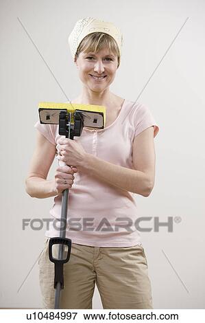 Smiling woman holding mop View Large Photo Image Stock Photo - Smiling woman holding mop. Fotosearch