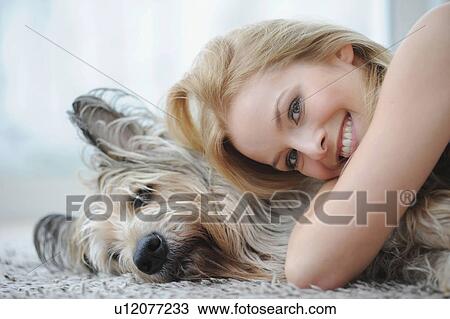 Smiling woman hugging dog at home View Large Photo Image Stock Image - Smiling woman hugging dog at home. Fotosearch