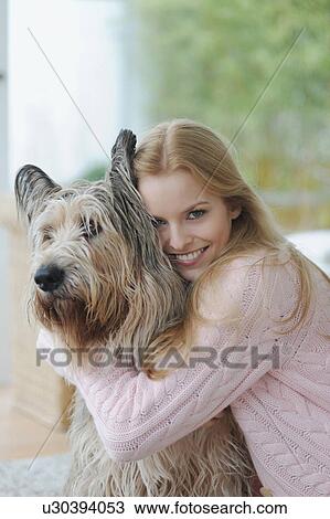 Smiling woman hugging dog at home View Large Photo Image Stock Image - Smiling woman hugging dog at home. Fotosearch