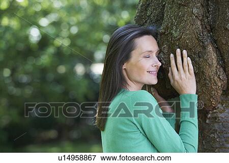 Smiling woman hugging tree View Large Photo Image Stock Photo - Smiling woman hugging tree. Fotosearch