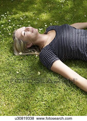 Smiling woman laying in grass View Large Photo Image Stock Photo - Smiling woman laying in grass. Fotosearch