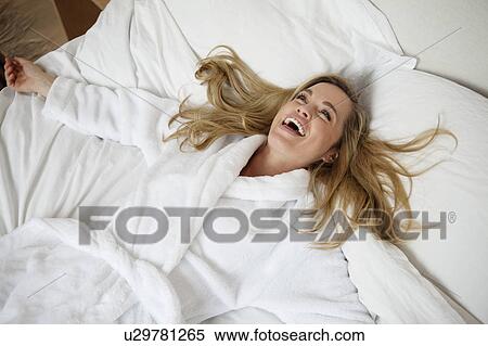 Smiling woman laying on bed View Large Photo Image Stock Photography - Smiling woman laying on bed. Fotosearch