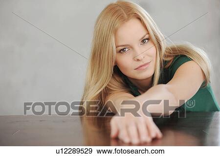 Stock Photo - Smiling woman laying on table. Fotosearch