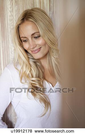 Stock Photo - Smiling woman leaning against wall. Fotosearch