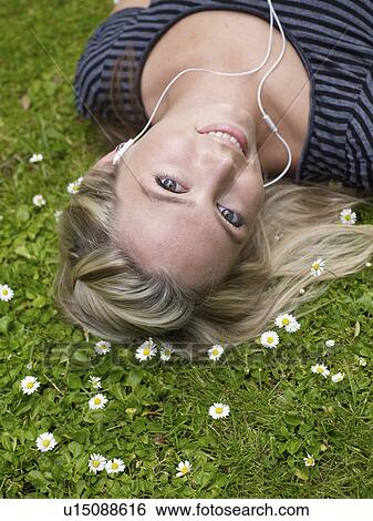 Smiling woman listening to headphones View Large Photo Image Stock Photograph - Smiling woman listening to headphones. Fotosearch