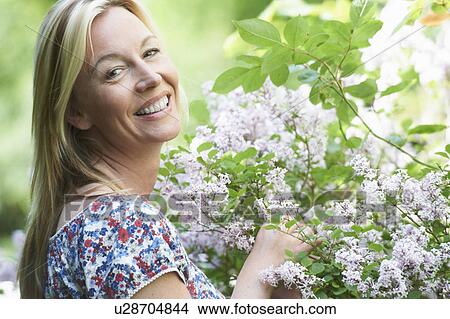 Smiling woman picking flowers View Large Photo Image Picture - Smiling woman picking flowers. Fotosearch