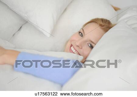 Smiling woman relaxing in cushions View Large Photo Image Stock Image - Smiling woman relaxing in cushions. Fotosearch